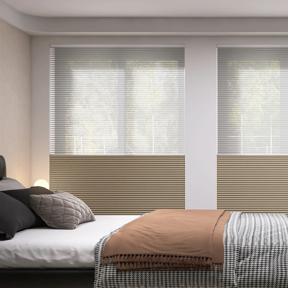Day and night cellular shades half open in a bedroom, showing both light filtering and blackout sections