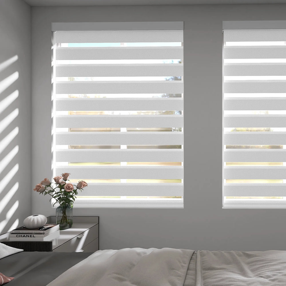 Motorized zebra shades in light-filtering mode softly diffusing sunlight in a modern bedroom