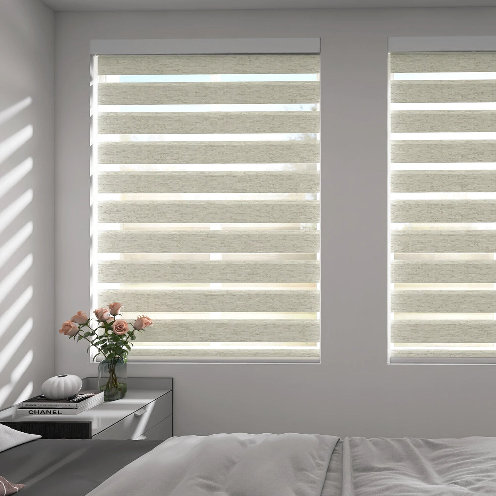 Motorized zebra shades in light-filtering mode softly diffusing natural sunlight in a cozy bedroom